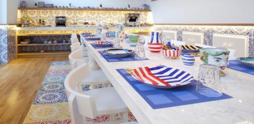 a long table with plates and bowls on it at Maison Kalea in Sorrento