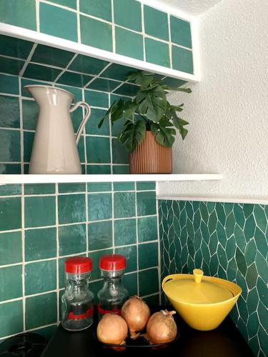 une cuisine avec des murs carrelés verts et un comptoir avec un bol dans l'établissement T1 bis stylé à 2 min de la mer, à Saint-Cyr-sur-Mer
