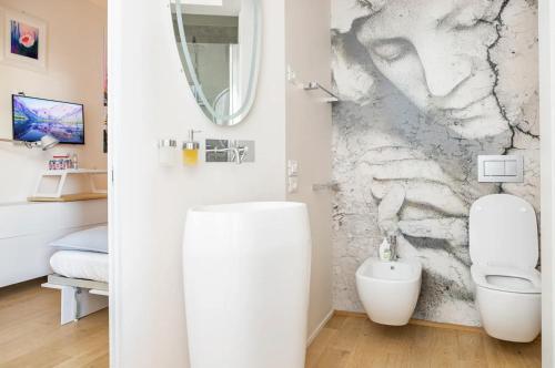bagno con servizi igienici bianchi e specchio di La stanza dell'architetto a Pescara