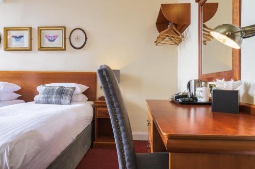 a bedroom with a desk and a bed and a desk and a chair at Old Waverley Hotel in Edinburgh