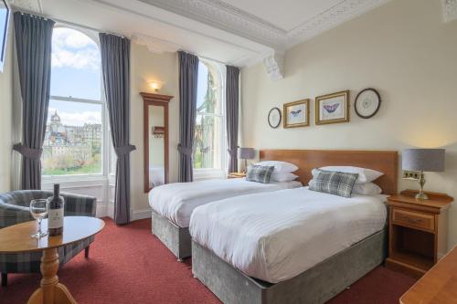 a hotel room with two beds and a table at Old Waverley Hotel in Edinburgh