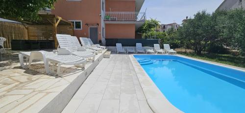 a swimming pool with lounge chairs and a swimming pool at Apartman Mia with pool1 in Split