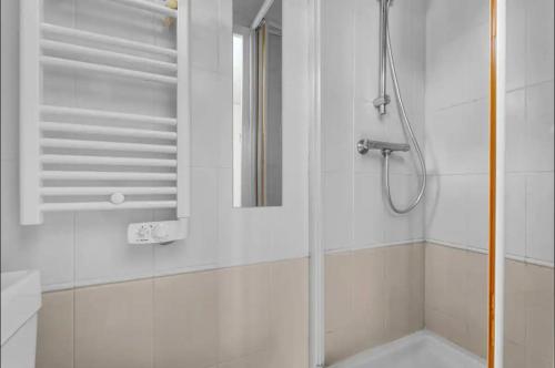 une douche avec une porte vitrée dans une salle de bain dans l'établissement Les demoiselles - wifi - parking, à Toulouse