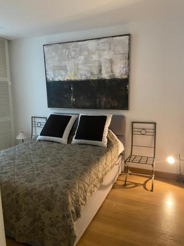 une chambre avec un lit et un tableau au mur dans l'établissement Surplombant le port de Beaulieu sur mer, à Beaulieu-sur-Mer