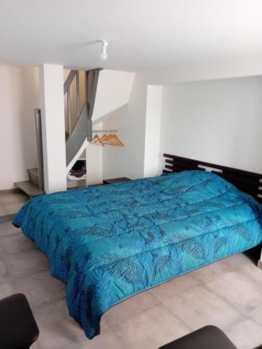 une chambre avec un lit avec une couette bleue dans l'établissement Chez Francine, à Lascabanes