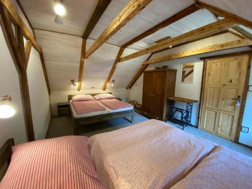sypialnia z 2 łóżkami w pokoju z drewnianym sufitem w obiekcie Apartmány u Dostálů w mieście Bedřichov