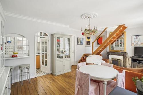 un salon avec une table et un canapé dans l'établissement L'Atelier du Peintre - Grand Triplex parisien, à Paris