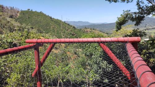 a red fence with a mountain in the background at La tina in Yolombó