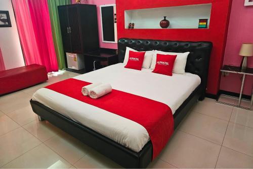 um quarto com uma cama grande e almofadas vermelhas e brancas em Phu Jaya Floresta Resort by ALPHATEL em Chiang Mai