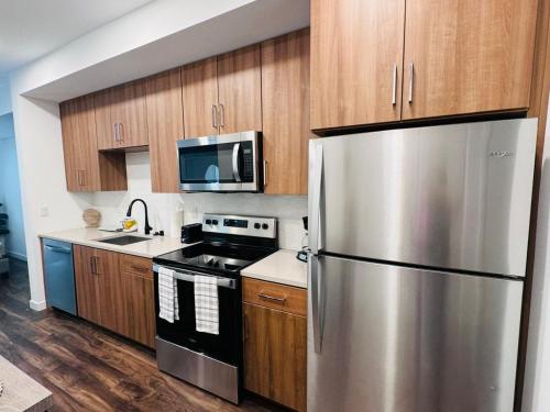 una cucina con frigorifero in acciaio inox e mobili in legno di Spectacular Cozy loft Hollywood FREE Parking a Los Angeles