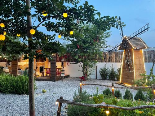 un jardín con un molino de viento y un limonero en Retro House Mộc Châu, en Mộc Châu