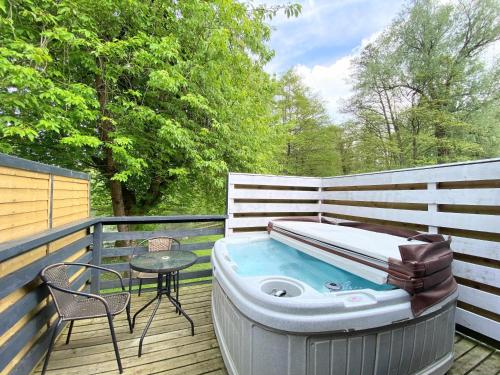 a hot tub on a deck with a table and a chair at Magpie 3 HuntersMoon-Longleat-Warminster-Bath in Warminster