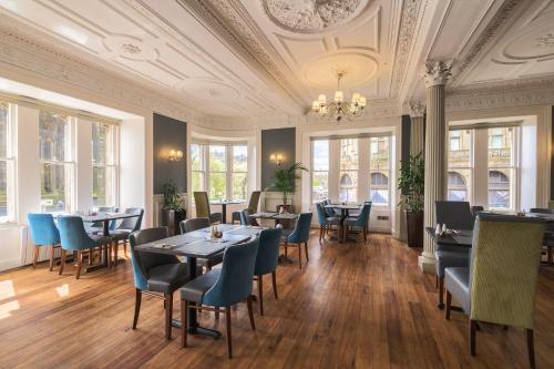 a dining room with tables and chairs and windows at Old Waverley Hotel in Edinburgh