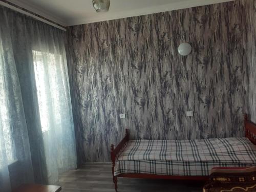 a bedroom with a bed and a wall covered in wallpaper at Sevan Writers House in Sevan
