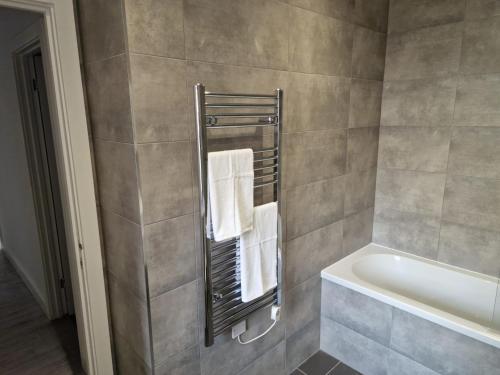 La salle de bains est pourvue d'un sèche-serviettes et d'une baignoire. dans l'établissement Suffolk House Apartments HU1, à Hull
