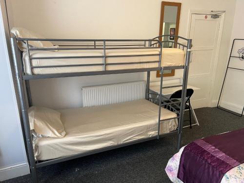 Ένα ή περισσότερα κρεβάτια σε δωμάτιο στο Backpackers Blackpool Hotel & Suites