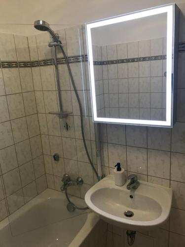 a bathroom with a sink and a tub and a mirror at Sonnenbalkon in Bad Elster