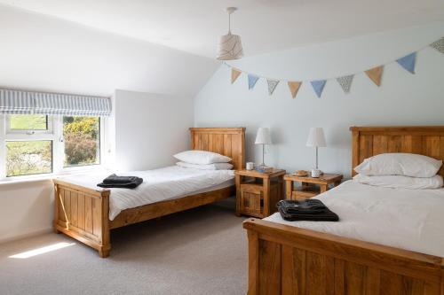 een slaapkamer met 2 bedden en een raam bij Finest Retreats - Bryn Du in Aberdaron