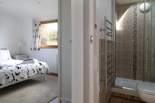 een badkamer met een bed, een douche en een wastafel bij Finest Retreats - Bryn Du in Aberdaron
