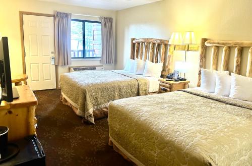 a hotel room with two beds and a window at Super 8 by Wyndham Bridgeview of Mackinaw City in Mackinaw City