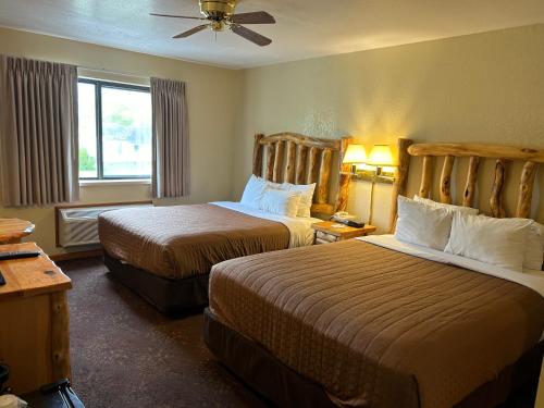 a hotel room with two beds and a window at Super 8 by Wyndham Bridgeview of Mackinaw City in Mackinaw City