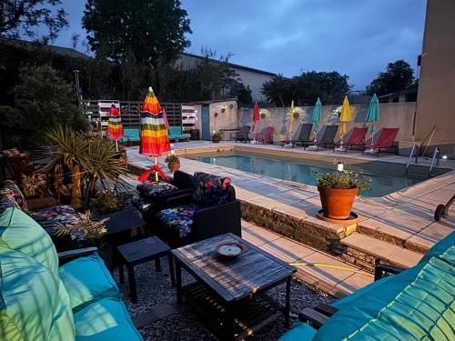 - une piscine avec des chaises et des parasols à côté dans l'établissement La Dolce Vita - Villa 4 chambres avec piscine et climatisation, à Sérignan