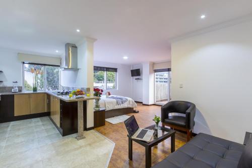 a kitchen and a living room with a bed and a couch at Gaviota Apartments & Suites in Cuenca