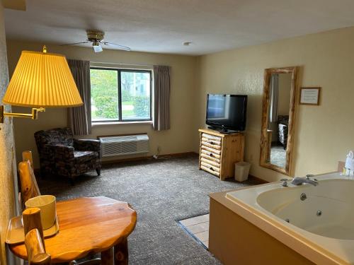 ein Wohnzimmer mit einer Badewanne und einem TV in der Unterkunft Super 8 by Wyndham Bridgeview of Mackinaw City in Mackinaw City