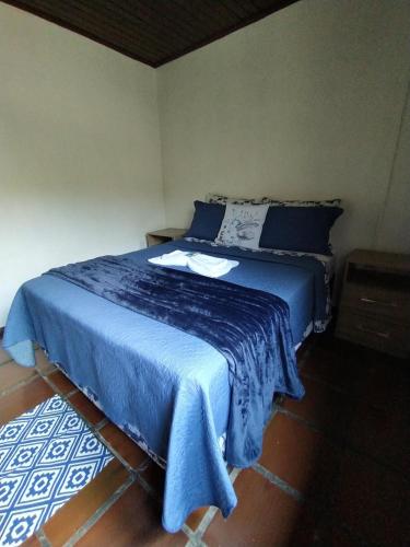 a bedroom with a blue bed with a blue blanket at Pousada do Pescador in Florianópolis