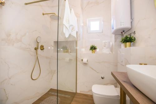 a bathroom with a shower and a toilet and a sink at Mind apartment and rooms in Poreč