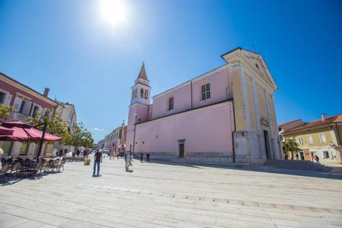 a group of people walking on a street next to a building at Mind apartment and rooms in Poreč