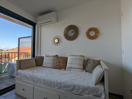 - une chambre avec un canapé et une grande fenêtre dans l'établissement Studio climatisé avec balcon - Vue montagne - 50 m de la plage, à Canet