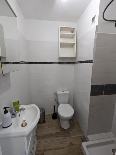 une salle de bain blanche avec des toilettes et un lavabo dans l'établissement Studio climatisé avec balcon - Vue montagne - 50 m de la plage, à Canet