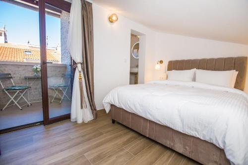 a bedroom with a large bed and a balcony at Mind apartment and rooms in Poreč