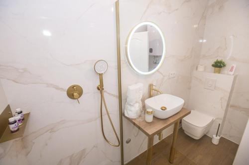 a white bathroom with a sink and a mirror at Mind apartment and rooms in Poreč