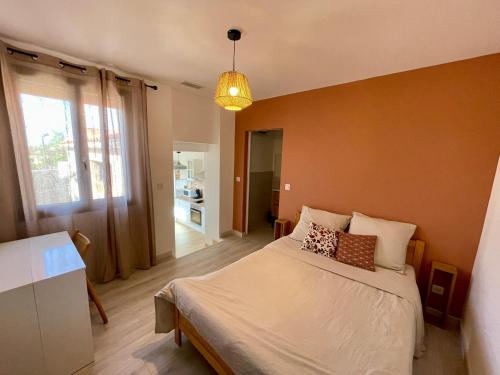 - une chambre avec un lit et une lampe pendant dans l'établissement Bel appartement à Céret, à Céret