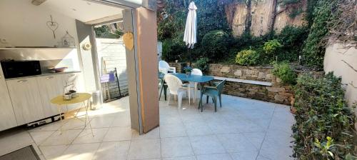 Il dispose d'une cuisine et d'une terrasse avec une table et des chaises. dans l'établissement Island of calm with sea view, à Saint-Tropez