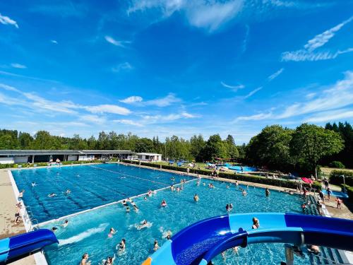 una gran piscina con gente en el agua en Landhotel Tanneneck - ideal für Gruppen, Familien und Hunde en Löffingen