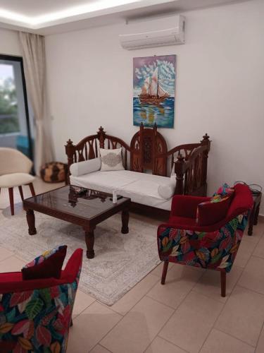 a living room with a couch and a table and chairs at Sandbox Apartment 4 Diani Beach Kenya in Ukunda