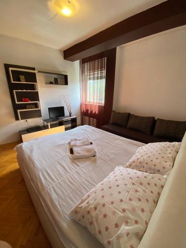 a bedroom with a large bed and a couch at Dena Apartment in Kumanovo