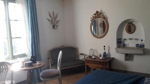 a room with a chair and a table and a mirror at Le Mas du Lac in Uzès