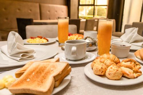 a table with plates of breakfast foods and drinks at Gran Hotel Toloma in Cochabamba