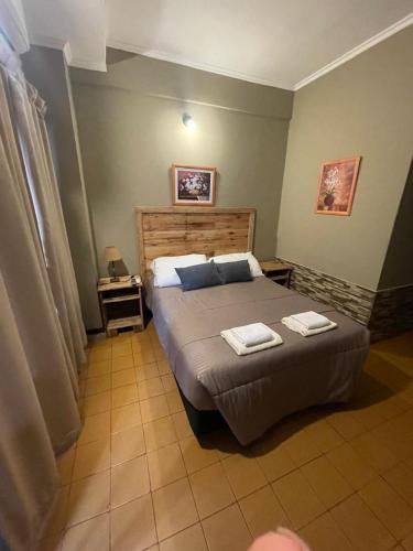 a bedroom with a bed with two towels on it at HOTEL BL in Puerto Iguazú