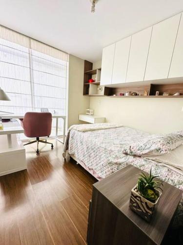 una camera da letto con un letto, una scrivania e una sedia di Cómodo y hermoso departamento amoblado ad Arequipa