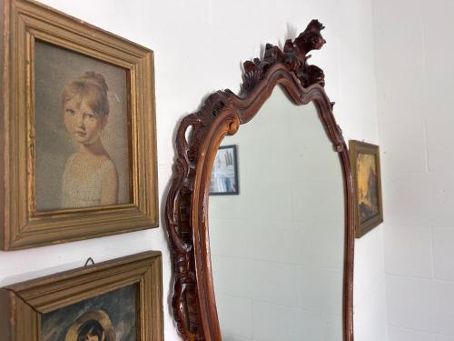 a mirror hanging on a wall with a picture of a woman at 87029house in Scalea