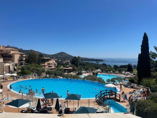 une grande piscine avec des gens dans un complexe hôtelier dans l'établissement Village cap Esterel, piscine, plage, à Saint-Raphaël