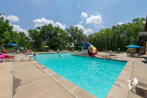 a swimming pool with a slide in the middle at 3BR Walk-In Near Silver Dollar City - Game Room - Pool - FREE TICKETS INCLUDED - RR93A in Branson