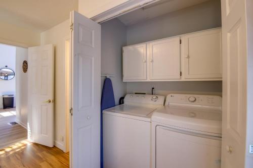 uma lavandaria com armários brancos e uma máquina de lavar e secar roupa em Stylish Smoky Mountains Cabin with Views and Game Room em Sevierville
