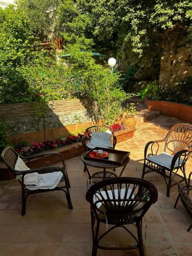 a patio with chairs and a table and a table and chairs at the secret garden in Vietri sul Mare