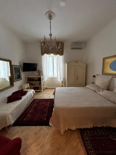 a bedroom with two beds and a chandelier at the secret garden in Vietri sul Mare